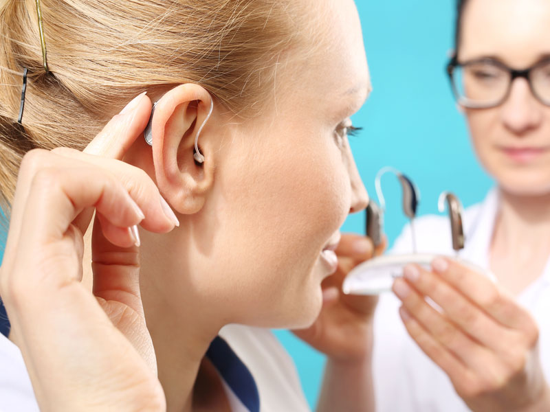 A woman trying on hearing aids