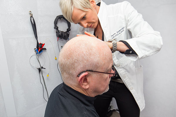 Patient having his ears checked during a hearing loss screening.